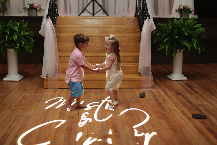 Custom wedding monogram projected on a reception dance floor